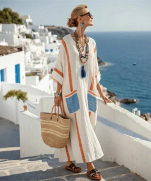 Side profile of a woman wearing the vibrant orange Elara maxi dress, highlighting the flowing silhouette.